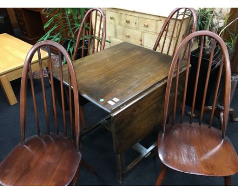 A set of four stick back Ercol Windsor chairs together with a small oak drop-leaf dining table.