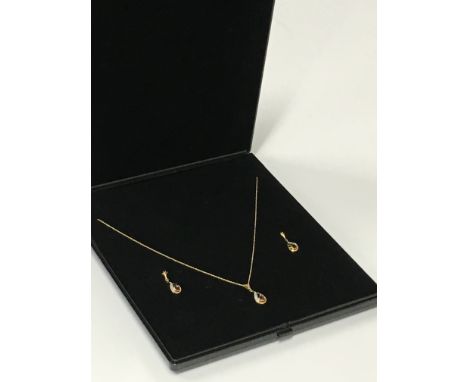 A 9 carat gold ruby and diamond set pendant and earring suite.