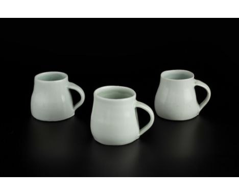 Edmund de Waal (b.1964) Three mugs light blue celadon glaze impressed potter's seals tallest 6.5cm high (3).