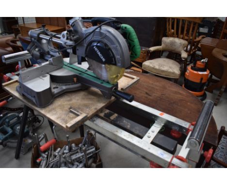 A roller style work bench and Hitachi mitre saw, powers up and runs but no warranties