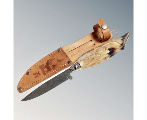 A hunting knife with goat hoof handle in a tooled stitched leather sheath 