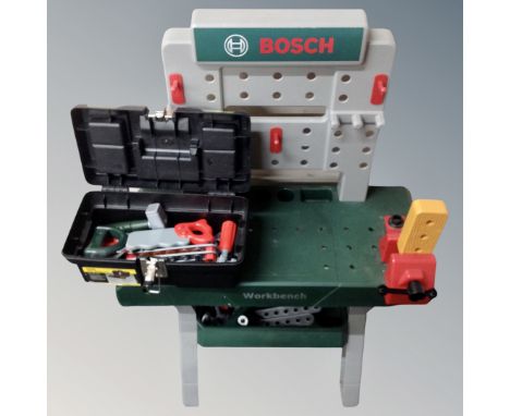 A child's toy Bosch work bench together with Stanley tool box containing assorted plastic tools and accessories 