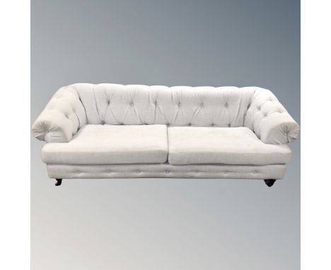 A Chesterfield settee upholstered in light grey fabric, length 229 cm