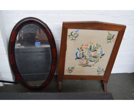 An oval mirror 69cmW together with an embroidered fireguard