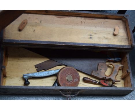 A vintage carpenters tool chest including wood saw, drill, and tape measure 79 x 43 x 16cm