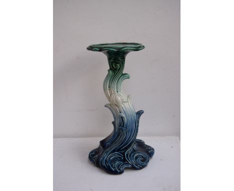 A ceramic stylized pot stand in the form of a crashing wave, blue and green glaze over cream ground, 50cmH