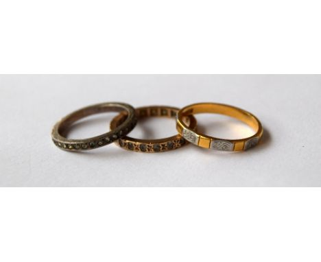 A 22ct gold and white metal ring together with a yellow metal and white stone eternity ring and a paste and silver eternity r