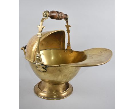 A Brass Helmet Shaped Coal Scuttle with Turned Wooden Handles, 45cms Long 