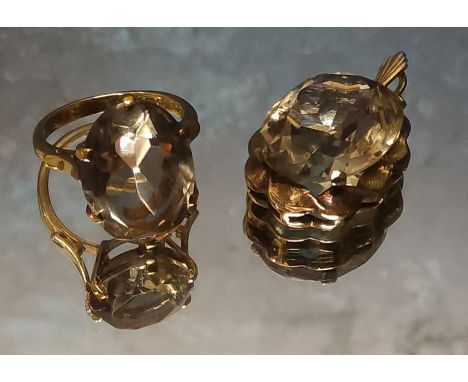 A 9ct gold cocktail ring claw set with an oval light smokey topaz 18 x 13mm, size N, 5g gross; a 9ct gold and light smokey to