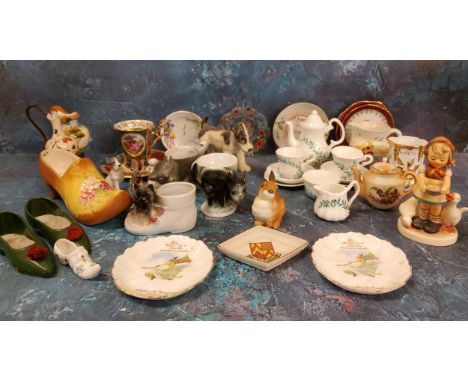 A Geman novelty egg cup, in the form of a cat, the handle with whistle, c.1920;&nbsp; an M J Hummel figure, Girl Feeding Gees