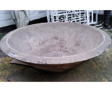 A substantial reconstituted dished saucer shaped garden planter 