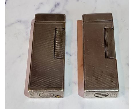 A Dunhill chrome light, engine turned, 6cm high;&nbsp; another (2) 