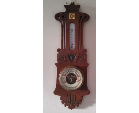 An Art Nouveau aneroid barometer, mercury thermometer, pierced and carved with stylised scrolls, 50cm high, c.1915 