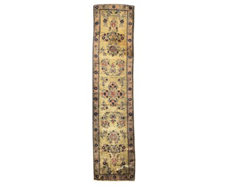 A Persian silk Kashan narrow runner, first quarter 20th century, the central field with floral design, on a beige ground, con