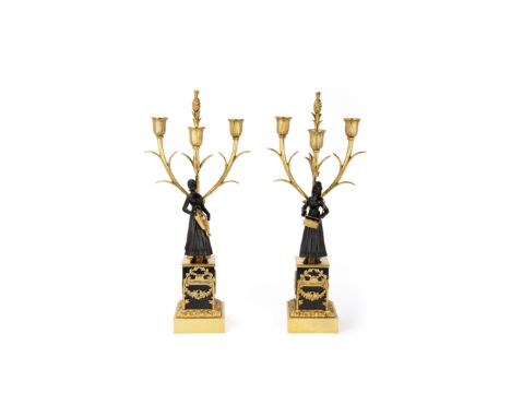 A pair of French gilt and patinated bronze three-light figural candelabra, late 19th century, one issuing from a rockwork col