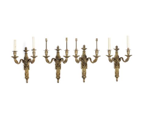 A set of four English gilt-bronze twin-light wall appliques, early 20th century, each surmounted with flambeau urn above tape