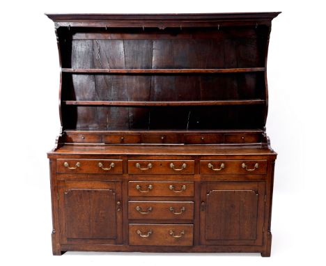 A George III country made oak dresser, third quarter 18th century, the raised shelf back with moulded cornice and shaped side