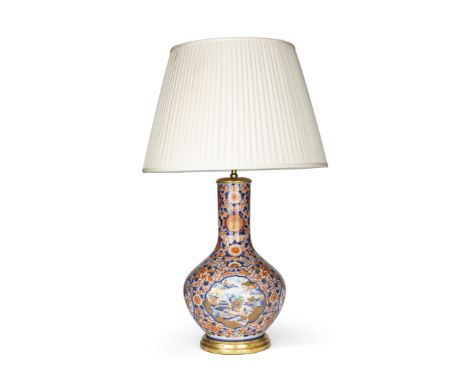A Japanese Imari bottle vase lamp, 19th century, with vignettes of buildings in a landscape and vases of flowers, amongst flo