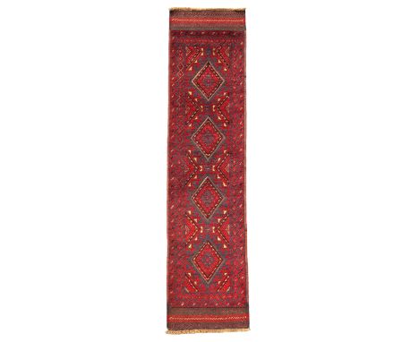 An Afghan Belouch runner, third quarter 20th century,&nbsp;the central field with four diamond medallions, on a midnight blue