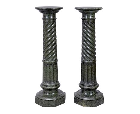 A pair of green serpentine marble pedestal columns, early 20th century, each with circular shelf over wrythen and stop-fluted