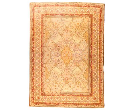 An Indian carpet, first quarter 20th century, the central field with stylised floral motifs and shaped tile design, on a beig