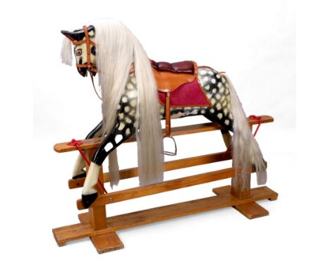 A painted rocking horse, first quarter 20th century, with dapple coat, leather saddle and synthetic mane and tail, on pine st