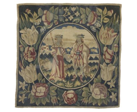 A North European tapestry panel, c.1700, woven in wools and silks, the central roundel depicting two figures wearing floral c
