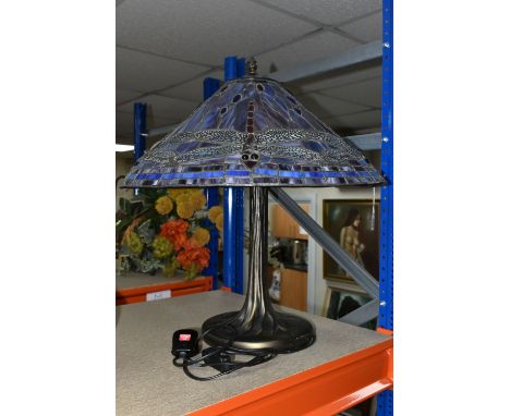 A TIFFANY STYLE LAMP, the metal base is naturalistic style, the leaded glass shade is multi coloured with a dragonfly design,