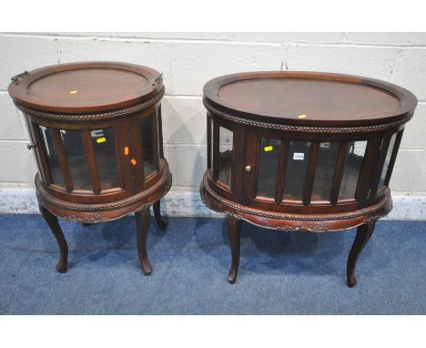 A REPRODUCTION MAHOGANY OVAL DRINKS CABINET, with a removable tray, bevelled glass panes and a single door, raised on cabriol