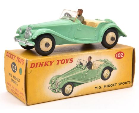 A Dinky Toys M.G. Midget Sports 102. Pale green body, cream interior and wheels. With grey suited driver. Boxed, very minor w