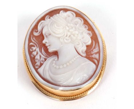 An 18ct mounted oval shell cameo brooch/pendant, carved with a bust of a lady, collet mounted with rope twist border, hinged 