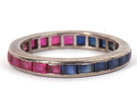 A ruby and sapphire eternity ring, the full hoop eternity ring set with sapphires to one half and rubies the other, all chann