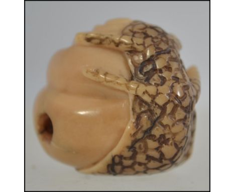 A Japanese netsuke in the form of a salamander holding a snail. H3cm