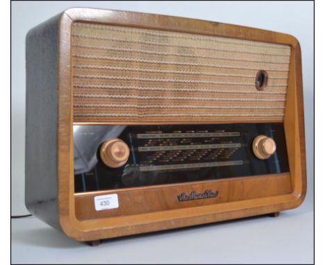 A vintage HMV Valve Radio walnut cased mid 20th century with knobs to front and mesh speaker atop. 