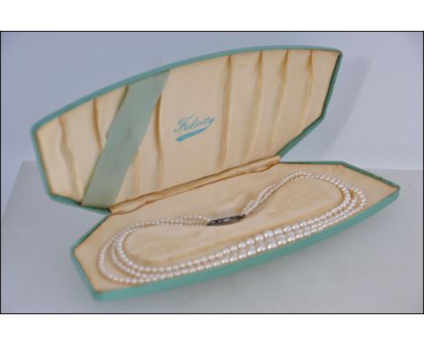 A three string faux pearl necklace by Felicity Opalescent having a silver and marcasite clasp in the original case