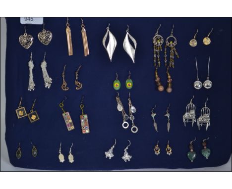 A collection of twenty earrings of differing styles to include enamel, drop, silver etc all mounted on a board
