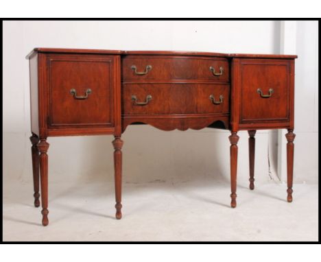 A Federal revival mahogany sideboard of bow fronted form being raised on turned legs with flame mahogany cupboards and drawer