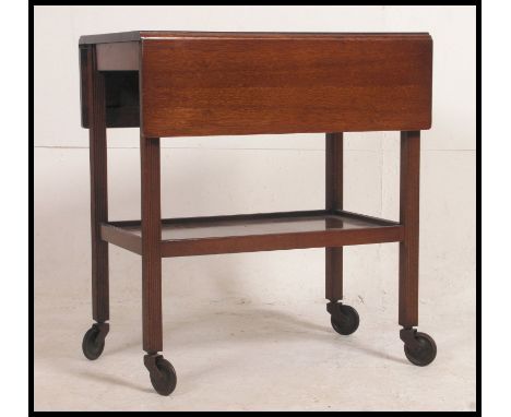 A 1930's vintage two tier oak tea trolley raised on castors along with a vintage stool of similar age. 