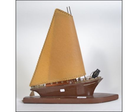 A 20th Century boat shaped wooden table lamp 'Margaret Ann'. brown painted, it rests on a wooden base, has twin anchors at th