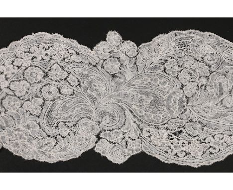 A Brussels lappet, circa 1730, delicately worked with blooms and curling foliage, oeil de perdrix fillings and scalloped bord