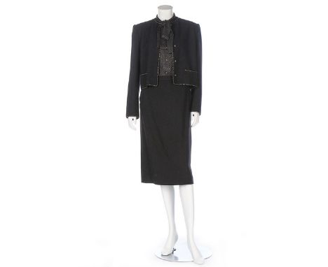 A Chanel Créations black wool-blend suit, early 1980s, labelled and size 10, the jacket with gilt lion head buttons, edged in