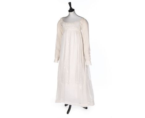 A whitework embroidered muslin dress, circa 1810, empire-line, long sleeves, the bodice with pulled and drawn threadwork, the