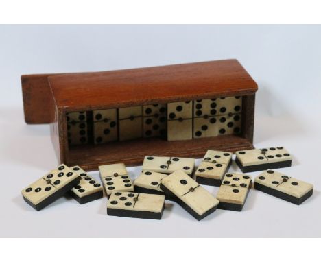 A set of early 20th century bone dominoes within fitted wooden case. 