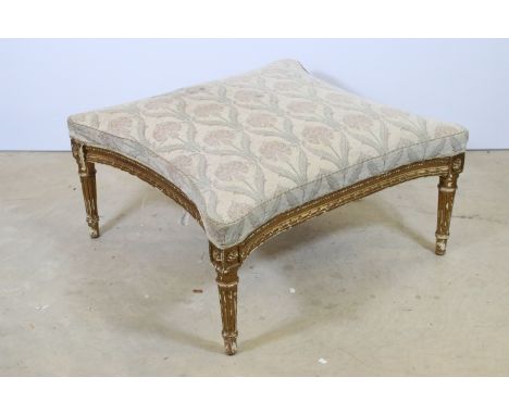 19th Century gilt and gesso footstool raised on reeded legs with moulded detail to the frame. Measures 33 x 71 x 71cm. 