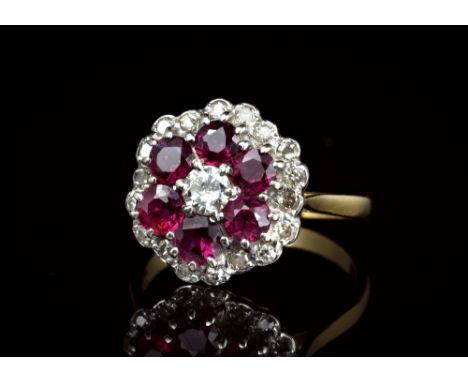 An 18ct yellow gold, ruby and diamond floral cluster ring, the central brilliant cut diamond within a two row cluster of six 