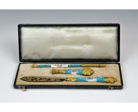 A cased Continental enamel and gilt metal three-piece writing set, 19th century, enamel handles with floral spray reserves on
