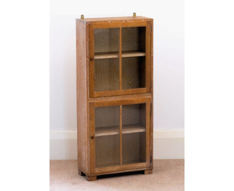 A mid-century limed oak glazed bookcase by Heals, with Heals ivorine label inset to inside of door, the upright rectangular c