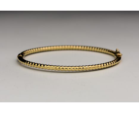 A 9ct yellow gold textured bangle
