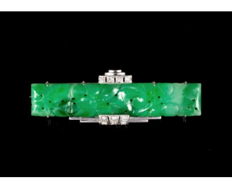 An Art Deco platinum, jade and diamond bar brooch, 1920s-30s, the mottled apple and spinach green jade carved and pierced wit