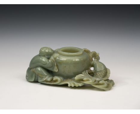 A Chinese carved celadon jade brush pot or washer, the central pot with a crouching boy to the left, his head and hands resti